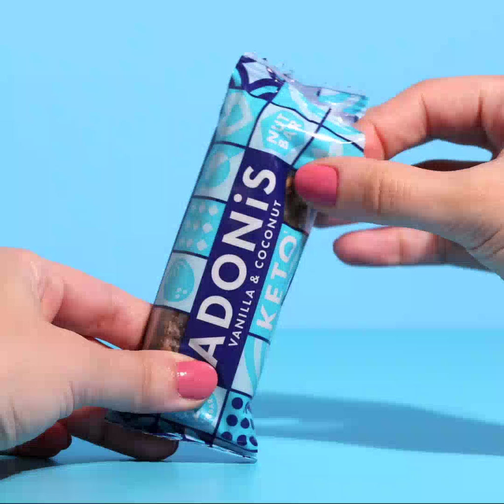 Vanilla & Coconut keto nut bar being broken apart and eaten